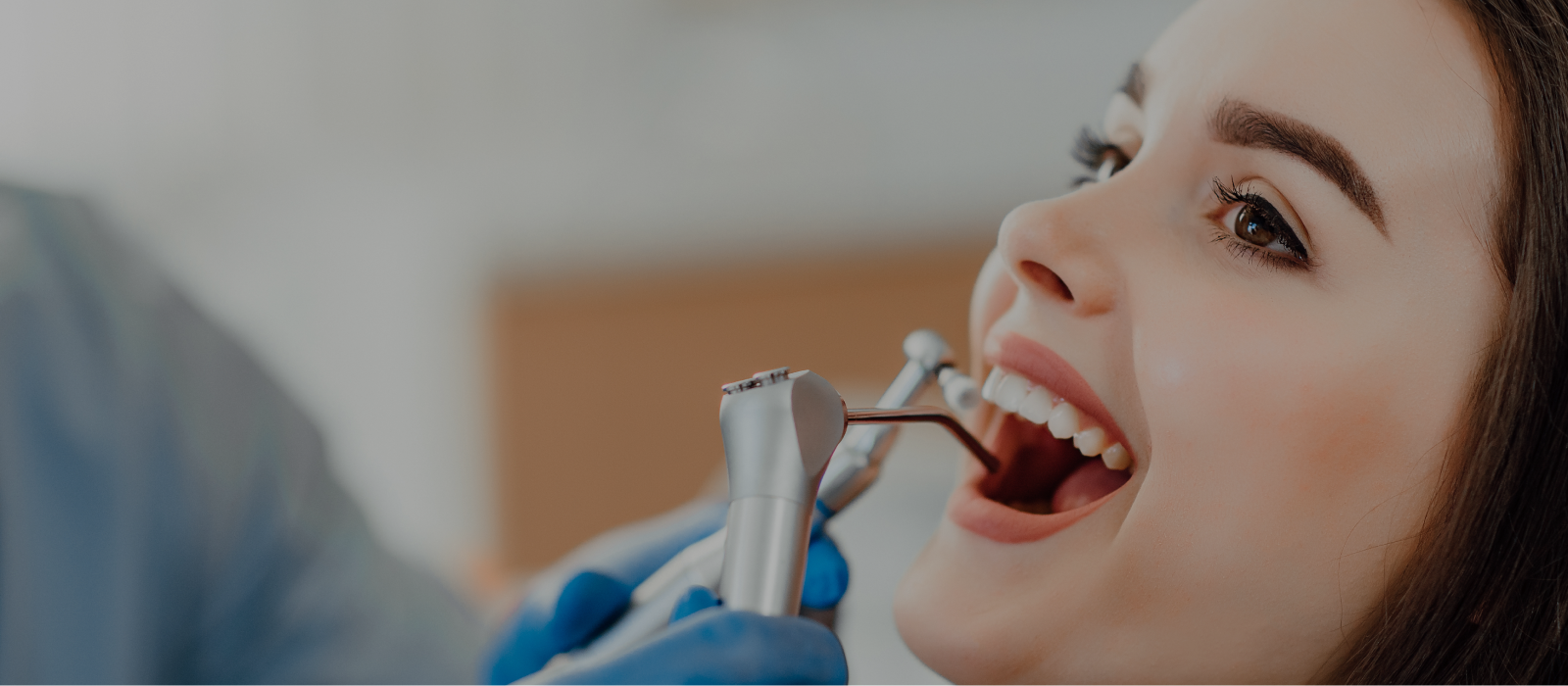 An image of a woman getting here teeth cleaned by the dentist.